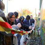 Students gather in front of the new mural dedicated to urban pollinators.