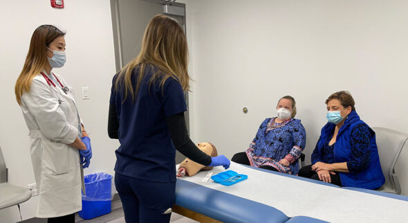 (L-R) DNP student Eun Jo Michelle Park and dentistry student Nikol Manov conduct a simulated exam involving a manikin and a standardized patient played by Bridget Brown in the UIC Nursing Schwartz Lab. Brown’s mom, Nancy (far right), acts as the patient's health coach. The simulation is part of an interprofessional project including UIC's colleges of Nursing, Pharmacy and Dentistry to train students to work with patients with disabilities.
