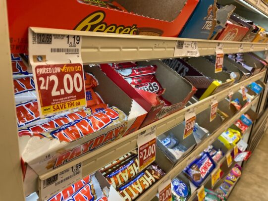 Rows of candy bars in a supermarket checkout lane.