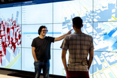 Fabio Miranda is an Assistant Professor at the Department of Computer Science at the University of Illinois Chicago. He is standing in front to a code generated map.