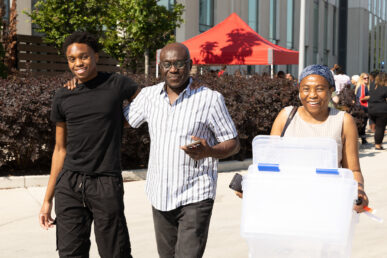First-year engineering student Benedict Udeogu and his parents smile after finishing moving items into the Academic and Residential Complex. (Photo: Jenny Fontaine/University of Illinois Chicago)