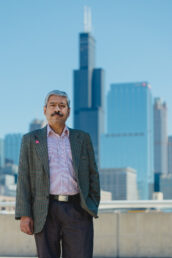 Dr. Sriraj is Director of UIC's Urban Transportation Center, he is standing outside with the Chicago skyline in the background.