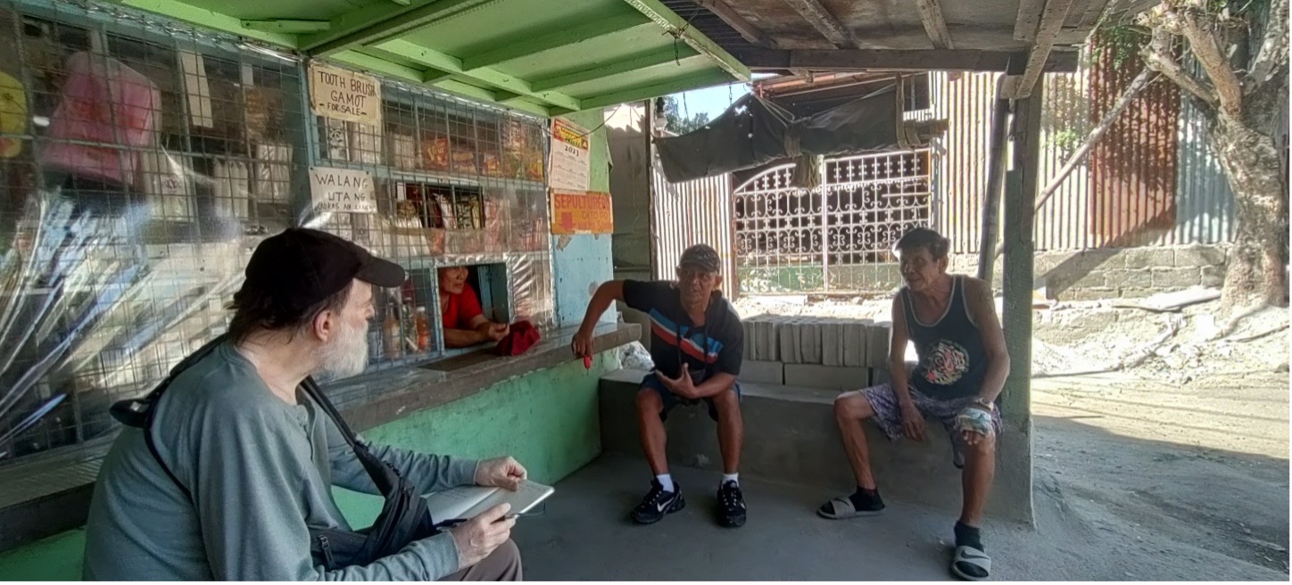 UIC's John Monaghan (left) interviews the sepulturero, or cemetery caretaker, in Mabalacat, Pampanga Province, Philippines, for information about potential WWII dead in cemeteries around Clark Airfield. (Photo: James Meierhoff)