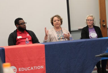 Three people sit on a panel