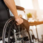 A disabled man is sitting in a wheelchair.