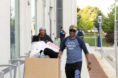 Ace Howard Thomas (left) gets help moving in from his father Jeffrey Thomas on Aug. 23. (Photo: Jenny Fontaine/UIC)