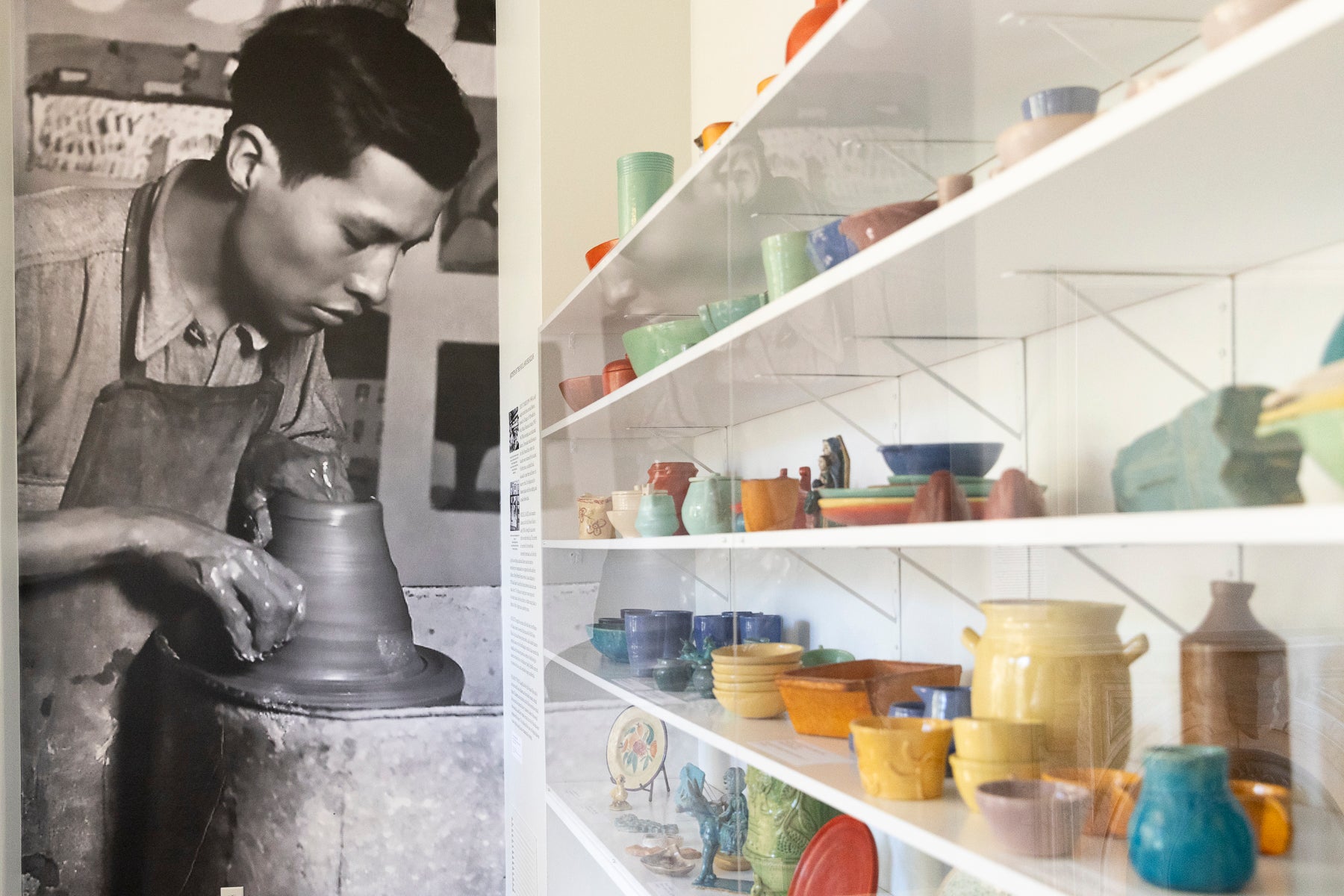 Ceramics in bold colors sit in a glass case at the Hull-House Museum.