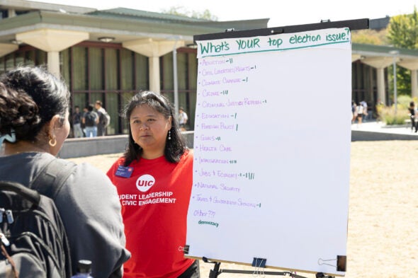 Rae Joyce Baguilat, director of Student Leadership and Civic Engagement at UIC, talks with students about the issues during a voter-information event on Sept. 17.