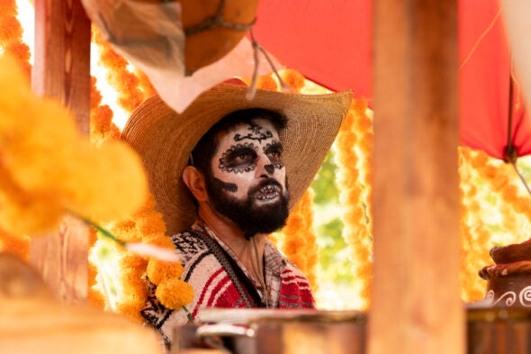 A man is dressed in an indigenous costume, complete with face paint.