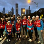 A group of students standing at the Chicago Marathon before dawn.