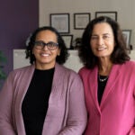 Two women stand side-by-side.