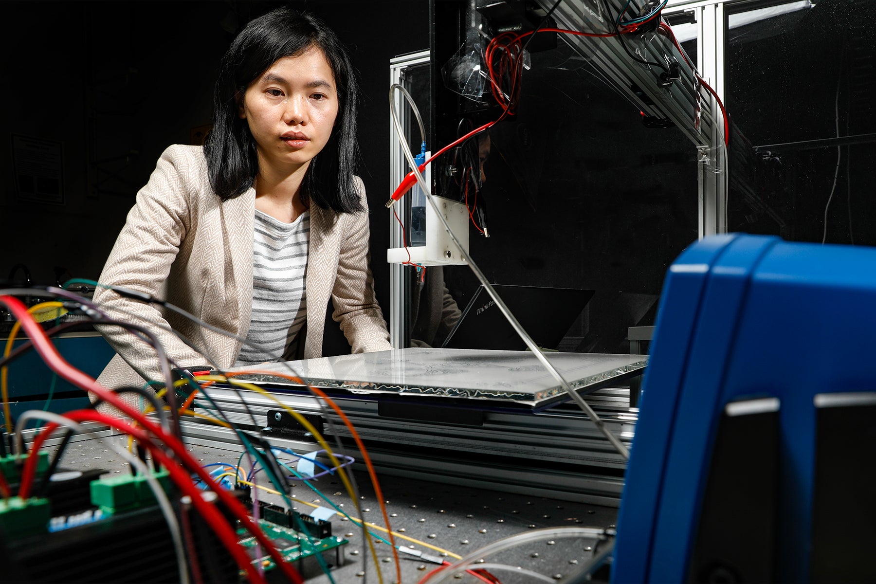 A woman works with engineering equipment in a laboratory.