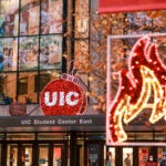 Photo of UIC Student Center East with a UIC circle logo decorated with holiday lights