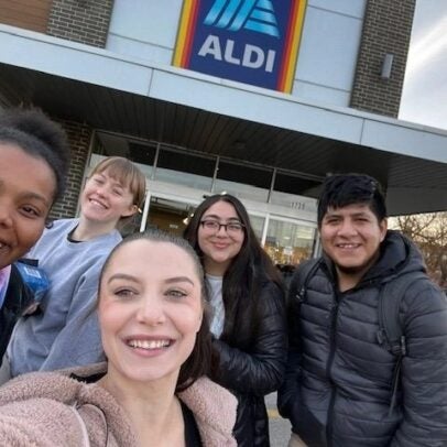 a group of people take a selfie outside an Aldi grocery store