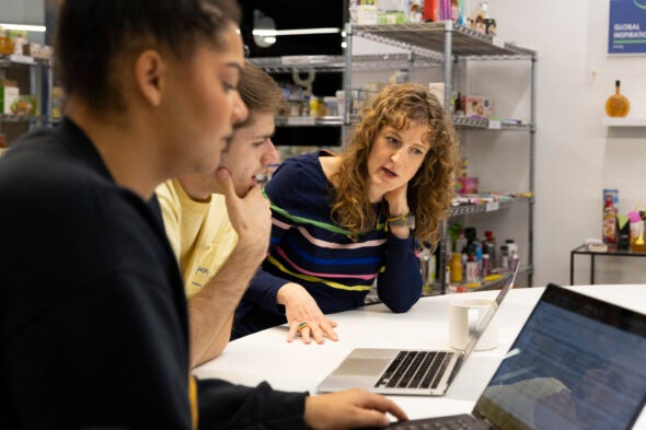 Three people working together at a computer.