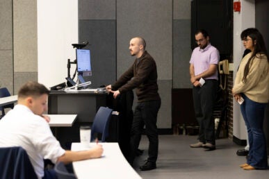 Students pictured giving a presentation in class.