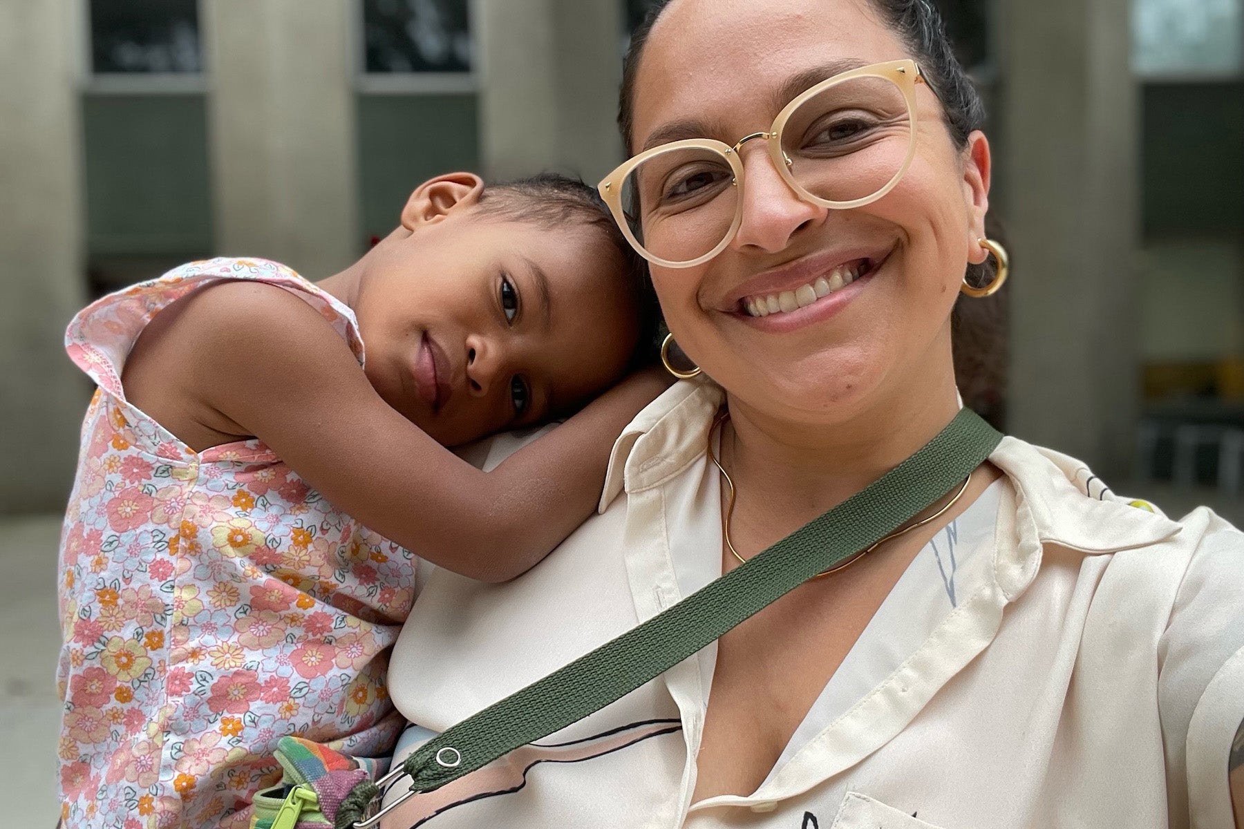 a woman wearing glasses takes a selfie with her young daughter